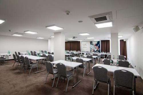 a room with tables and chairs in a classroom at Hotel Slovakia in Trenčianske Teplice