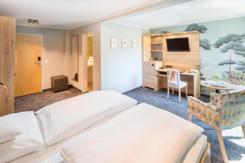 a hotel room with a bed and a desk at Romantik Hotel Waldschlösschen in Schleswig