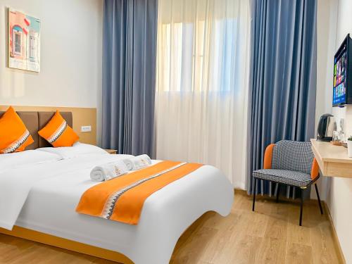 LedineOrange inn Apartment 桔子酒店的一间卧室，配有一张床、一张桌子和一把椅子