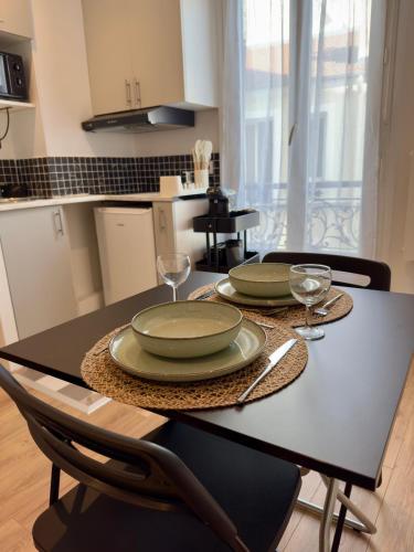 - une table à manger avec 2 assiettes et des verres à vin dans l'établissement Superb and Elegant Apartment in Paris' Heart, à Paris