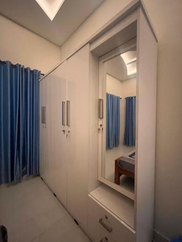 a dressing room with a mirror and blue curtains at Chaithanya Residency Near to NIT in Kunnamangalam