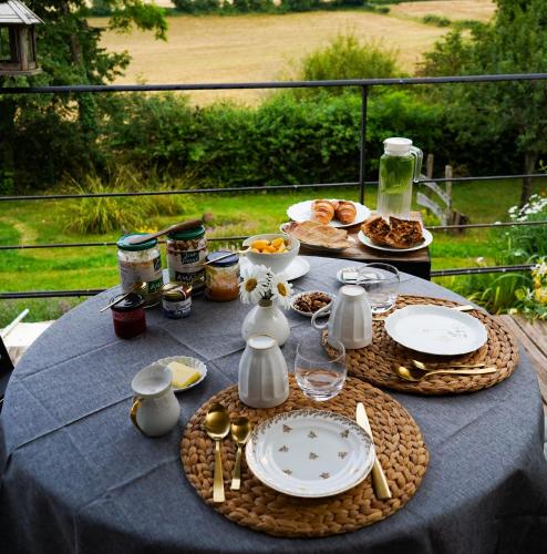 een tafel met daarop borden met eten bij Le Petit Pré in Bouhy