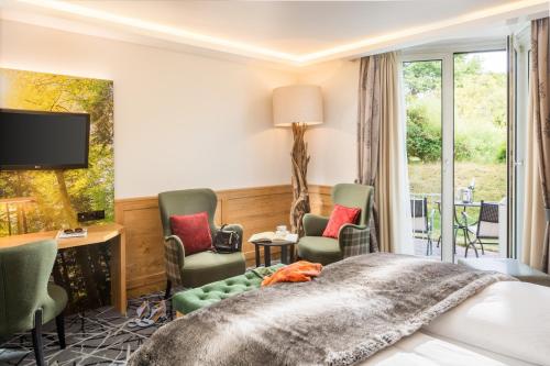 a hotel room with a bed and a desk and chairs at Romantik Hotel Waldschlösschen in Schleswig