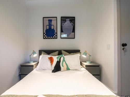 a bedroom with a white bed with two night stands at Walk in Hostel Faro Airport in Faro