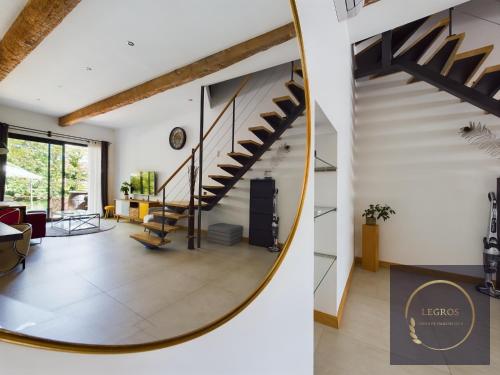 - un salon avec un escalier en colimaçon et un miroir dans l'établissement La terrasse du pêcheur, à LʼIsle-sur-la-Sorgue