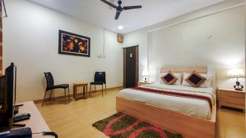 a bedroom with a bed and a table and chairs at Rainforest Resort and Spa, Igatpuri -Nature's Luxury Awaits in Igatpuri