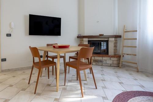 a dining room with a table and chairs and a fireplace at Tenuta Concamarau in Muro Leccese