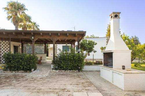 a house with a fireplace in the yard at Tenuta Concamarau in Muro Leccese