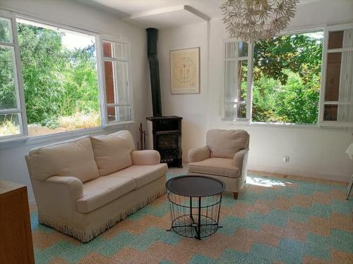 un salon avec un canapé, deux chaises et une table dans l'établissement La Colline aux Oiseaux, La tranquillité des bois, à Molières-sur-Cèze