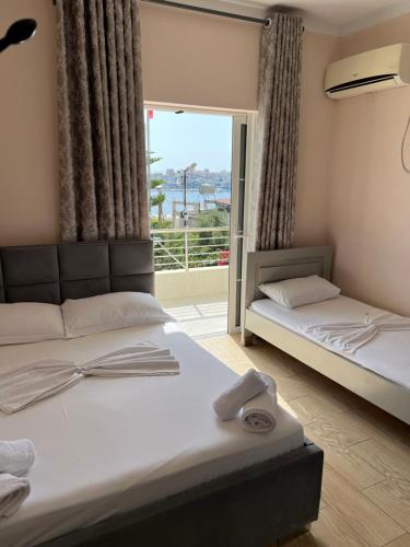 a bedroom with two beds and a window at Villa AlMar in Sarandë