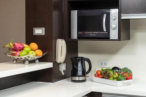 a kitchen with a bowl of fruit and a microwave at Sathorn Vista, Bangkok - Marriott Executive Apartments in Bangkok