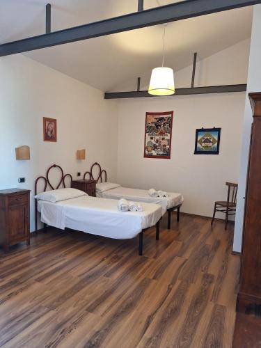 two beds in a room with wooden floors at Monastero San Lodovico - Orvieto in Orvieto