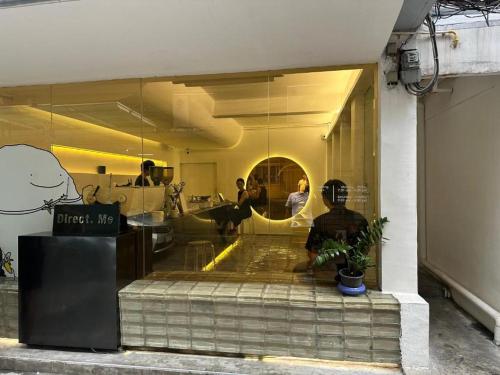 a man sitting in front of a store window at Bangkok Dreamcatcher hostel in Bangkok