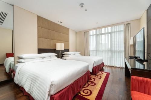 a hotel room with two beds and a flat screen tv at Sathorn Vista, Bangkok - Marriott Executive Apartments in Bangkok