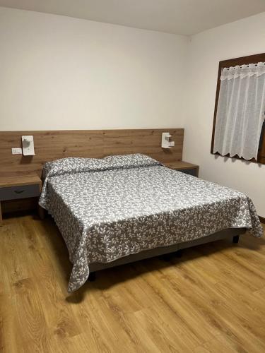 a bedroom with a bed and a wooden floor at Cantarane Guest House in Rovarè
