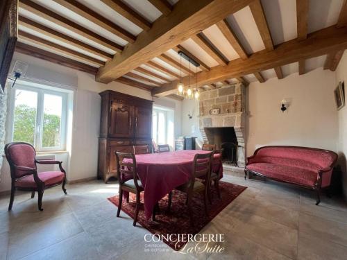 une salle à manger avec une table et une cheminée dans l'établissement La croix Luce, à Cherbourg en Cotentin