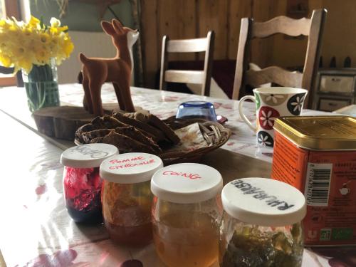 een tafel met potten met voedsel en een hertenbeeldje bij A l'orée de soi - Maison forestière de la Soie - Eco gîte, chambres d'hôtes, camping au pied des Vosges in Saint-Sauveur