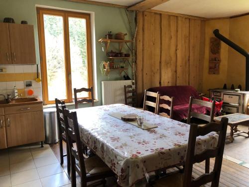 une cuisine avec une table recouverte d'une nappe dans l'établissement A l'orée de soi - Maison forestière de la Soie - Eco gîte, chambres d'hôtes, camping au pied des Vosges, à Saint-Sauveur