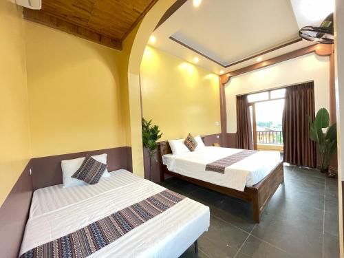 a bedroom with two beds and a window at Sky Bay Lodge in Ha Giang