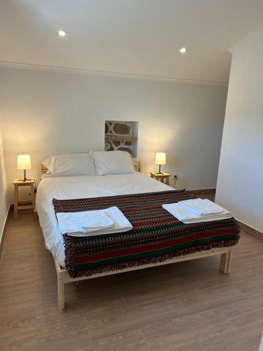 a bedroom with a large bed with two lamps at Casanova Country Villa in Santo António das Areias