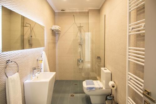 a bathroom with a sink and a toilet and a shower at Pezodromos Apartments in Filiatra