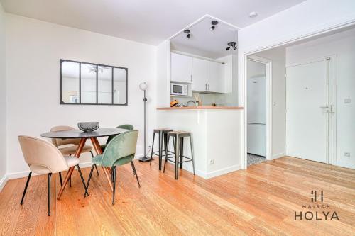 une cuisine et une salle à manger avec une table et des chaises dans l'établissement Le Verdoyant - À Auteuil - 312B, à Paris