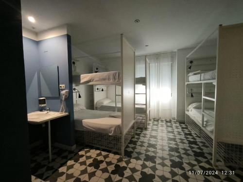 a room with two bunk beds with a sink and a mirror at Feel Hostels Soho Malaga in Málaga