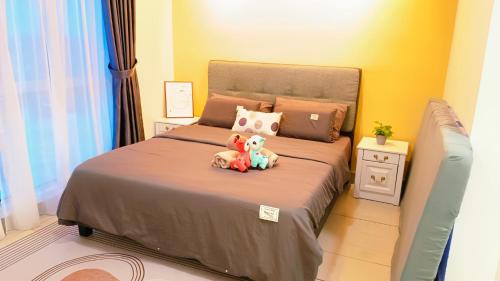 two stuffed animals sitting on a bed in a bedroom at Kulai d putra suites beside ioiMall near JPO and Airport in Kulai