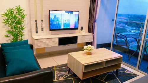 a living room with a tv and a coffee table at Kulai d putra suites beside ioiMall near JPO and Airport in Kulai