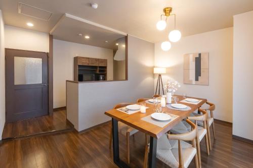 a dining room with a wooden table and chairs at Precioso Umeda Central Osaka - Self Check-In Only in Osaka