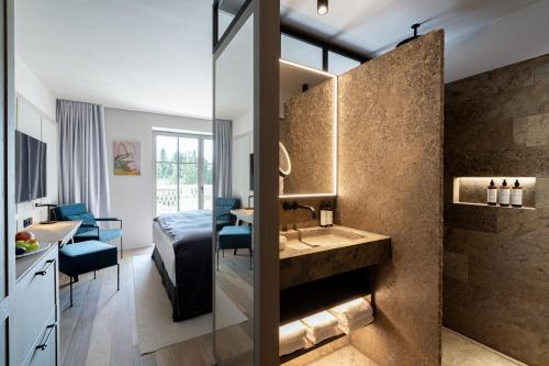 a bathroom with a sink and a dining room at Parkhotel Egerner Höfe in Rottach-Egern