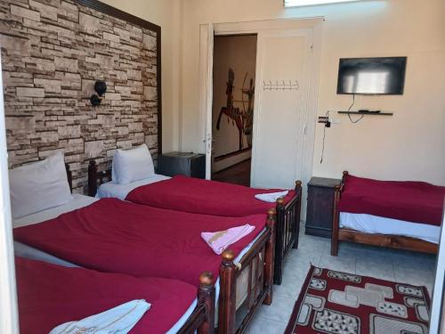 a bedroom with two beds with red sheets at New Palace Hotel in Cairo