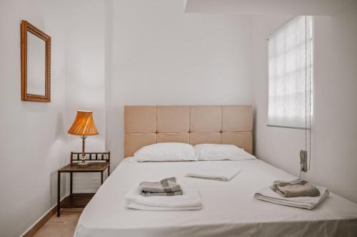 a bedroom with a large white bed with towels on it at K&F Apt in the center of Ierapetra by Hospi in Ierápetra