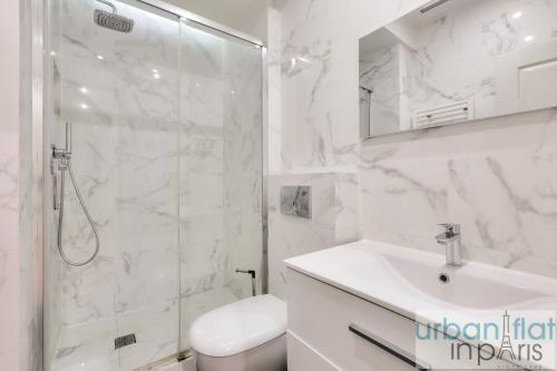 une salle de bain blanche avec une douche et un lavabo dans l'établissement 60-LUXURY PARISIAN HOME SEBASTOPOL (2DG), à Paris