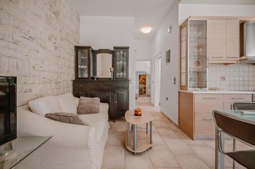 a living room with a white couch and a table at K&F Apt in the center of Ierapetra by Hospi in Ierápetra