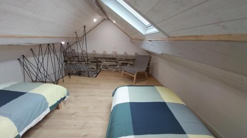 a small room with two beds and a chair at Le Scailleteux, petite maison de mineur, climatisée non accessible PMR in Fumay