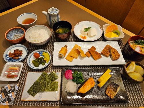 a table topped with different types of food on plates at Smile Hotel Tokushima in Tokushima
