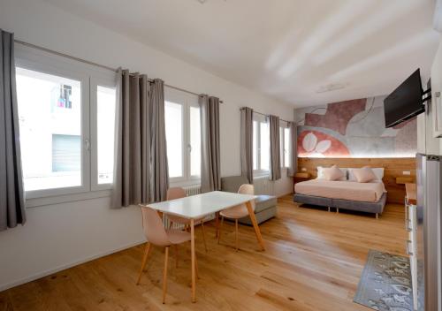 a living room with a table and a bed at Fully Furnished Pink Apartment 2 in Treviso