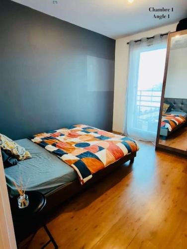 une chambre avec un lit et un miroir au mur dans l'établissement Appartement Cergy- Face à l'ESSEC à 4 min du RER A, à Cergy