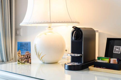 a lamp sitting on a table next to a phone at Hotel Il Nido in Amalfi