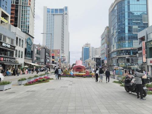 a street in a city with people walking and buildings at Elbon the stay with A1 in Busan