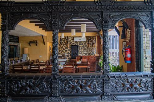 a restaurant with wooden tables and chairs in a building at Pokhara Boutique Hotel in Pokhara
