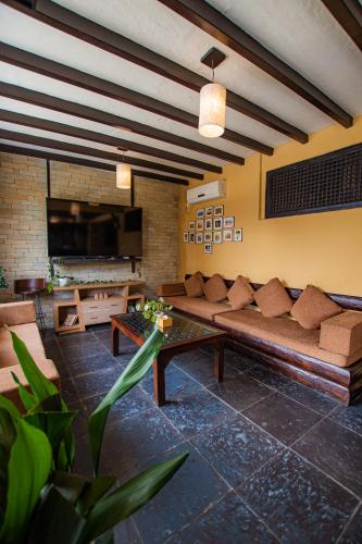 a living room with a couch and a tv at Pokhara Boutique Hotel in Pokhara
