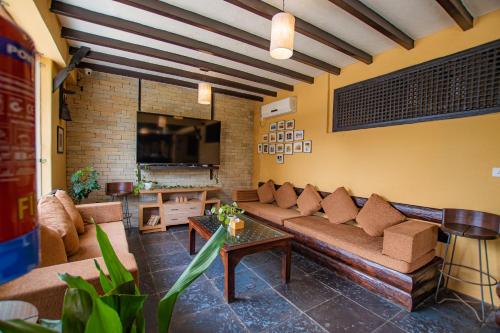 a living room with a couch and a tv at Pokhara Boutique Hotel in Pokhara