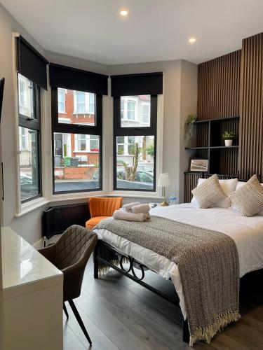 a bedroom with a large white bed and windows at Luxury Guest House in Vibrant London Area in London