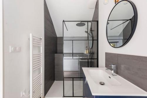 une salle de bain avec un lavabo et un miroir dans l'établissement Grange Caliana, à La Vineuse