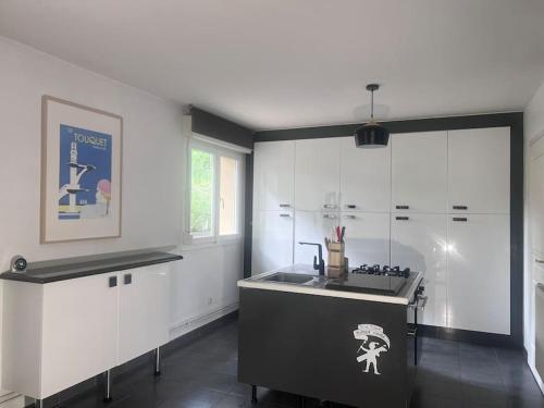 une cuisine avec des armoires blanches et un évier dans l'établissement Villa Baccara Le Touquet, à Le Touquet-Paris-Plage