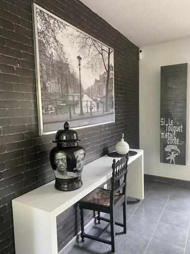 Cette chambre comprend une table avec un vase et une chaise. dans l'établissement Villa Baccara Le Touquet, à Le Touquet-Paris-Plage