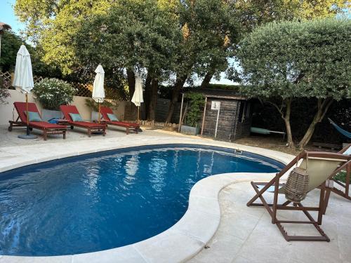 - une piscine avec des chaises longues et des chaises de jardin dans l'établissement La Provence, à Maubec