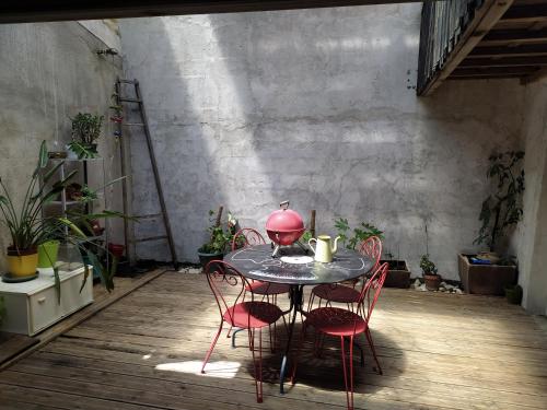 une table avec quatre chaises et une lampe rouge dessus dans l'établissement appartement de charme, à Bessan